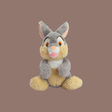 Magic Tour Club Bambi Tambor pluche knuffel van 25 cm in zachte grijze en beige tinten met een vriendelijke glimlach.